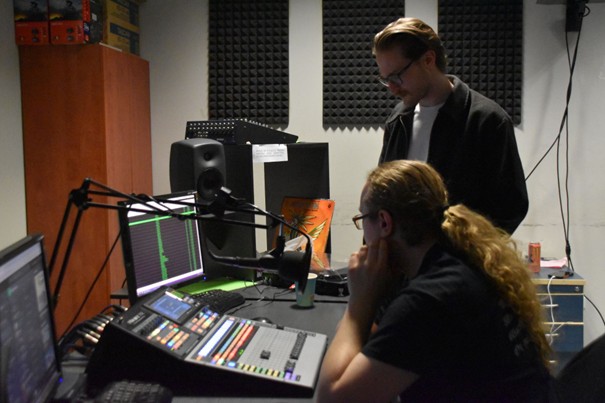 Dwóch realizatorów pracujących przy konsolecie