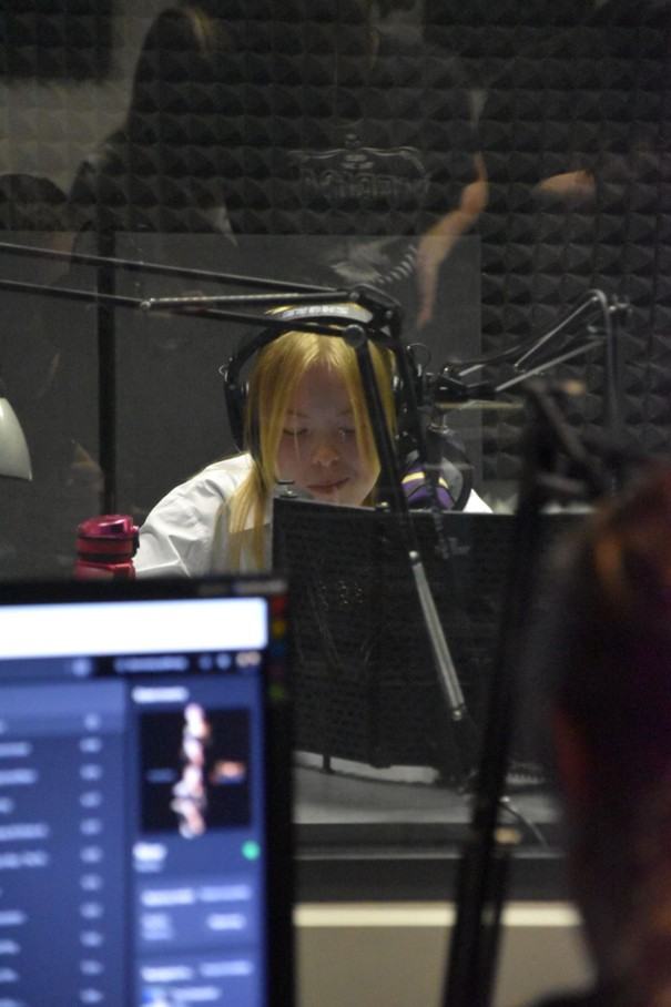 Studentka przy mikrofonie w studiu radiowym